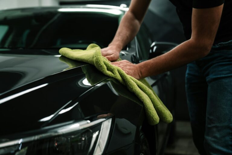 man cleans the car body with a towel. auto care