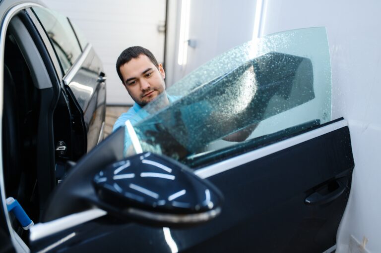 Male worker tries on sheet of car tinting